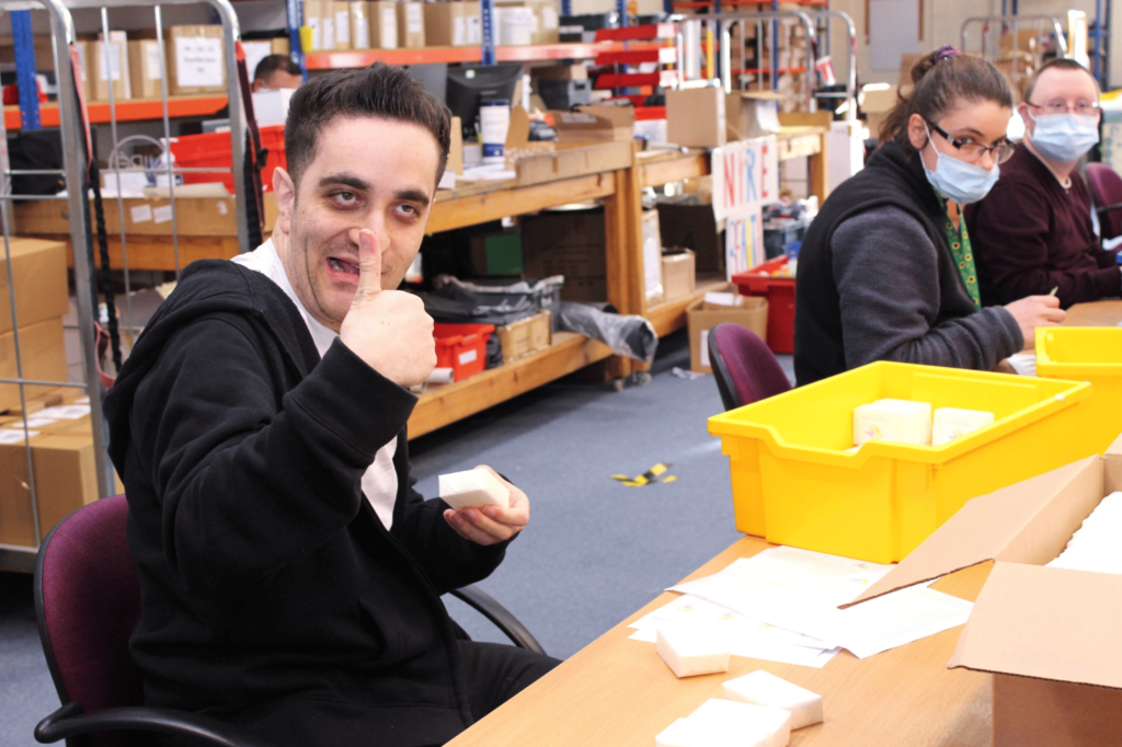 Man with thumbs up whilst packaging